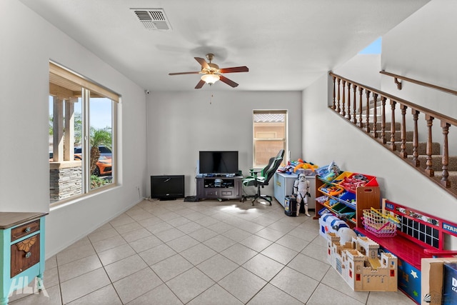 tiled living room with stairway, a ceiling fan, and visible vents