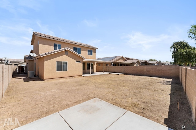 back of property with a fenced backyard, a patio area, stucco siding, and cooling unit