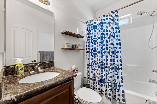 full bath featuring vanity, a textured wall, shower / bath combination with curtain, and toilet
