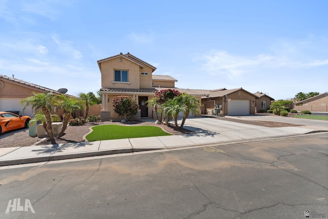 view of front facade with fence, stucco siding, a tiled roof, concrete driveway, and an attached garage