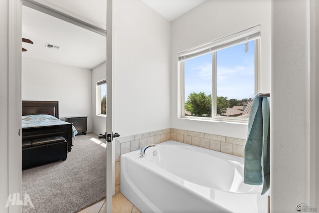 ensuite bathroom with tile patterned floors, ensuite bathroom, a garden tub, and visible vents