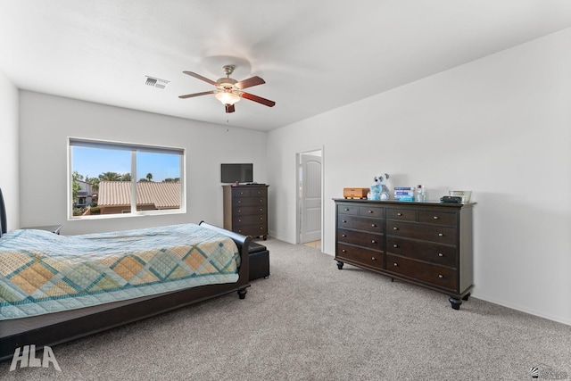 bedroom with visible vents, baseboards, ceiling fan, and light carpet