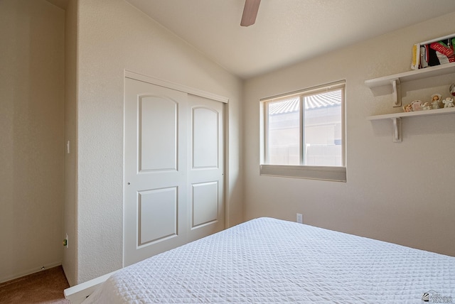 carpeted bedroom featuring a closet, a ceiling fan, and vaulted ceiling