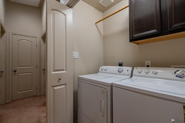 laundry room with cabinet space, visible vents, light carpet, and washer and clothes dryer