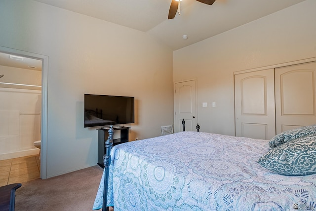 bedroom with carpet floors, baseboards, a closet, connected bathroom, and lofted ceiling