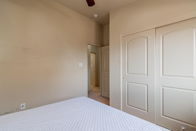 unfurnished bedroom featuring ceiling fan, a closet, and carpet flooring