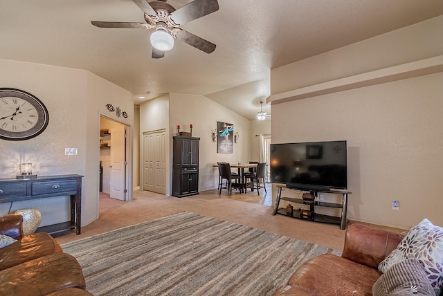 living room with baseboards, ceiling fan, vaulted ceiling, and light carpet