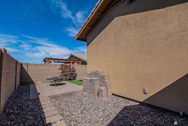 exterior space with a fenced backyard, a patio area, and stucco siding