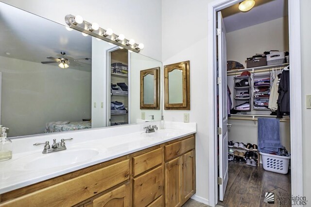 7955 E 37th St, Yuma, AZ 85365 - full bathroom featuring double vanity, a spacious closet, a ceiling fan, and wood finished floors