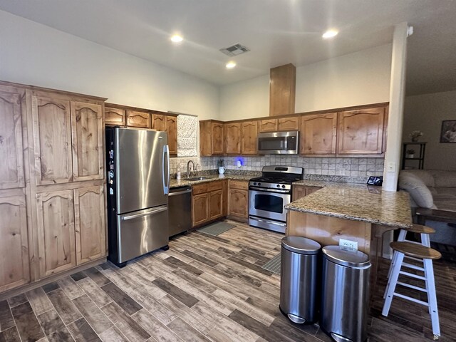 7955 E 37th St, Yuma, AZ 85365 - kitchen with appliances with stainless steel finishes, a peninsula, backsplash, stone counters, and a breakfast bar