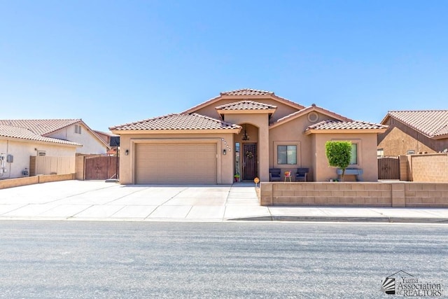 7955 E 37th St, Yuma, AZ 85365 - mediterranean / spanish-style home featuring a garage, stucco siding, driveway, and a gate