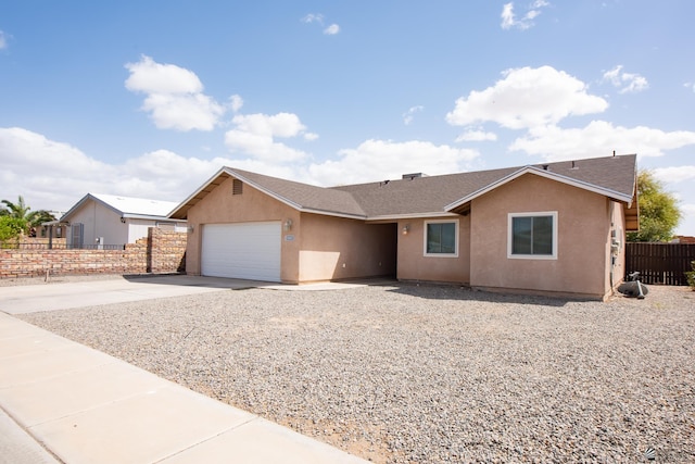 ranch-style house with fence, roof with shingles, an attached garage, stucco siding, and concrete driveway
