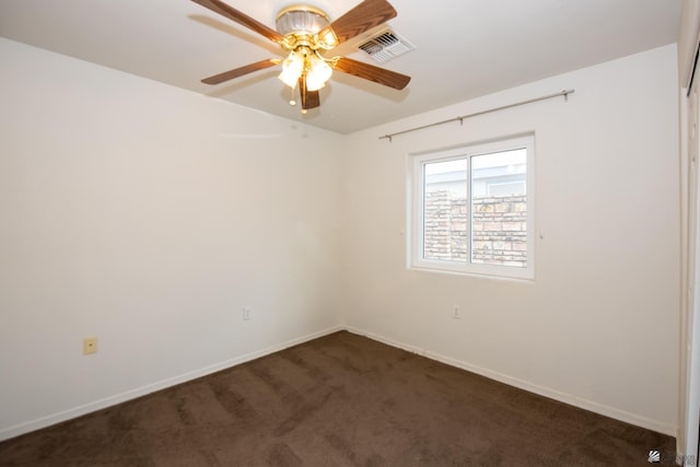 unfurnished room featuring a ceiling fan, baseboards, visible vents, and dark carpet