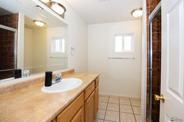 bathroom with tile patterned floors, plenty of natural light, a tile shower, and visible vents