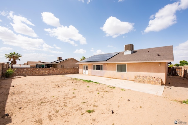 back of property with roof mounted solar panels, stucco siding, a patio area, and a fenced backyard
