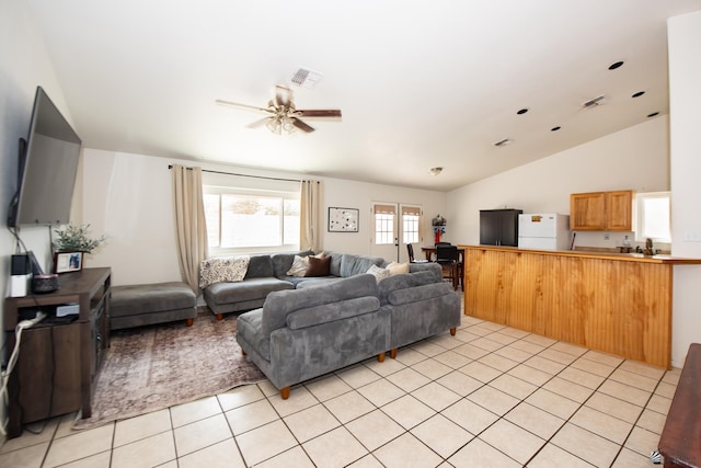 living area with visible vents, ceiling fan, light tile patterned floors, and lofted ceiling