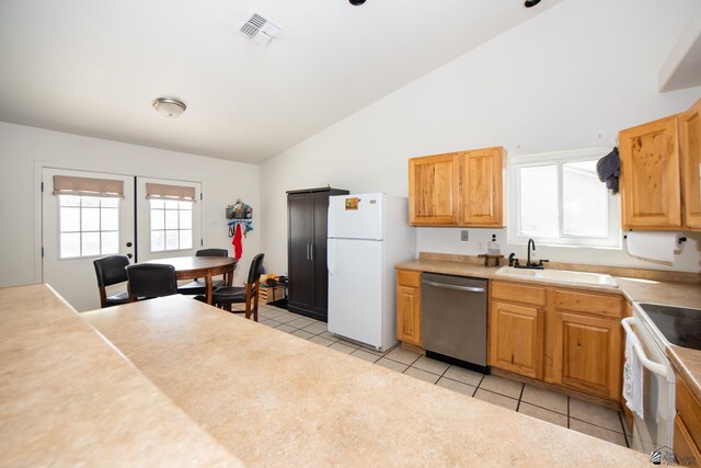 kitchen with plenty of natural light, visible vents, a sink, light tile patterned floors, and white appliances