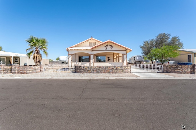 view of front facade with a fenced front yard, stucco siding, and a tiled roof