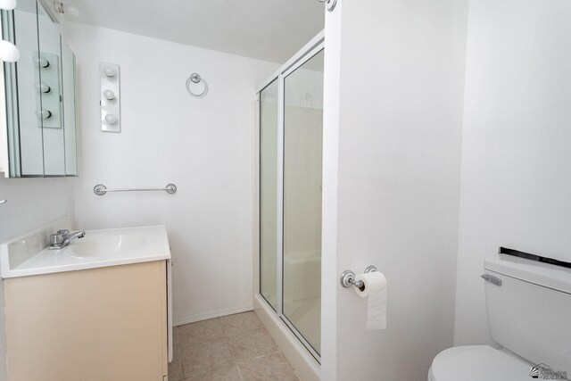bathroom with vanity, tile patterned flooring, a shower stall, and toilet