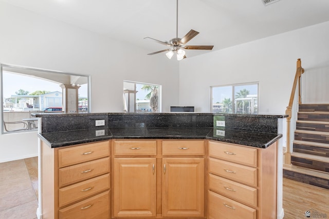 kitchen featuring plenty of natural light, dark stone counters, ceiling fan, and light brown cabinets