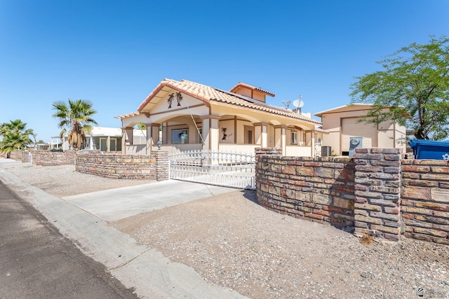 view of front of house with fence, a tile roof, stucco siding, a porch, and a gate