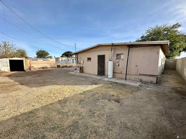 2176 E 14th Pl, Yuma, AZ 85365 - rear view of property with a storage unit, concrete block siding, fence, and an outbuilding