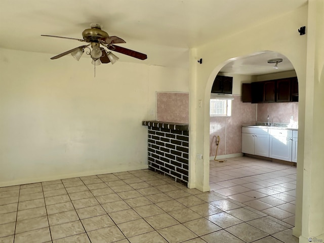 2176 E 14th Pl, Yuma, AZ 85365 - unfurnished living room featuring arched walkways, ceiling fan, a sink, and light tile patterned floors