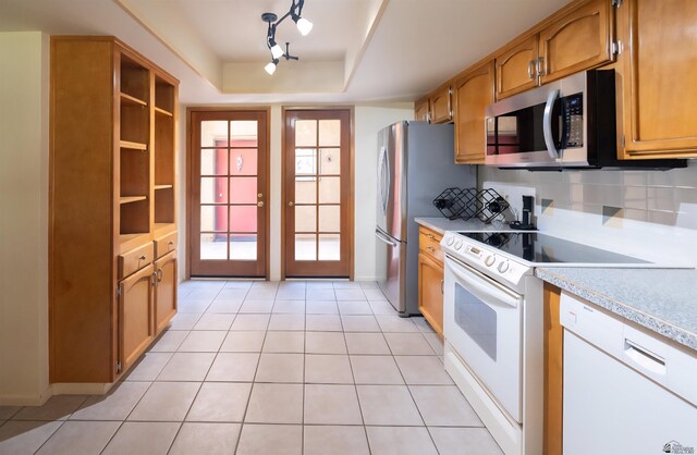 800 E Country Club Dr Unit 26, Yuma, AZ 85365 - kitchen with appliances with stainless steel finishes, light countertops, tasteful backsplash, light tile patterned floors, and brown cabinetry