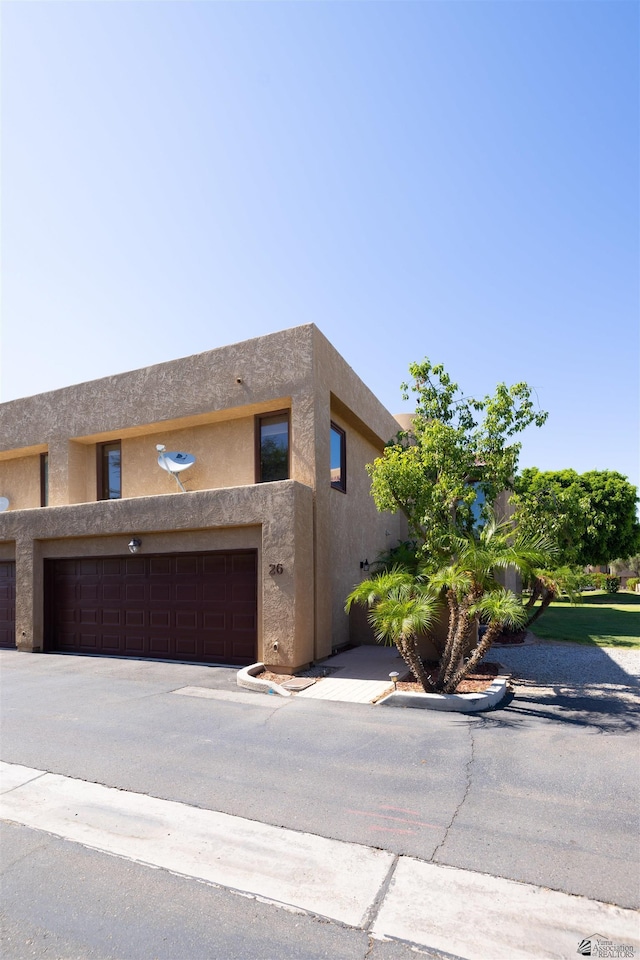800 E Country Club Dr Unit 26, Yuma, AZ 85365 - view of front of home featuring a garage, stucco siding, and driveway
