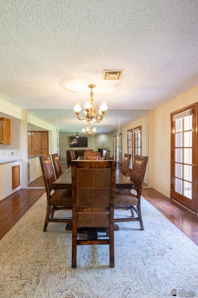 800 E Country Club Dr Unit 26, Yuma, AZ 85365 - dining room featuring a chandelier, a textured ceiling, and wood finished floors