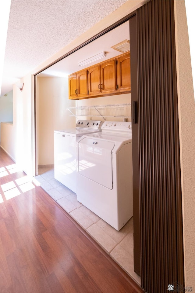 800 E Country Club Dr Unit 26, Yuma, AZ 85365 - laundry room featuring washing machine and clothes dryer, cabinet space, light wood-style flooring, and a textured ceiling