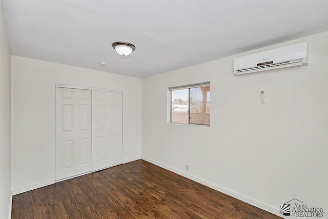 13466 E 47th St, Yuma, AZ 85367 - unfurnished bedroom featuring a wall mounted AC, dark wood-style flooring, and a closet