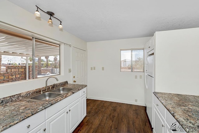 13466 E 47th St, Yuma, AZ 85367 - kitchen with dark wood-style flooring, healthy amount of natural light, white cabinets, a textured ceiling, and freestanding refrigerator