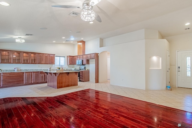 11594 E 27th Pl, Yuma, AZ 85367 - kitchen with a ceiling fan, lofted ceiling, a kitchen bar, appliances with stainless steel finishes, and arched walkways