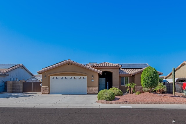 11594 E 27th Pl, Yuma, AZ 85367 - view of front facade with stucco siding, a tile roof, concrete driveway, an attached garage, and roof mounted solar panels