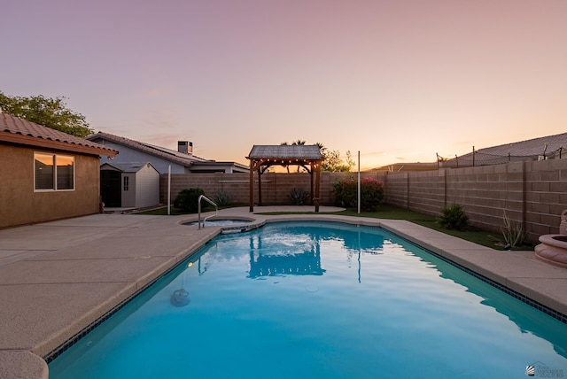 11594 E 27th Pl, Yuma, AZ 85367 - pool at dusk featuring a storage unit, a fenced backyard, an outdoor structure, and a patio