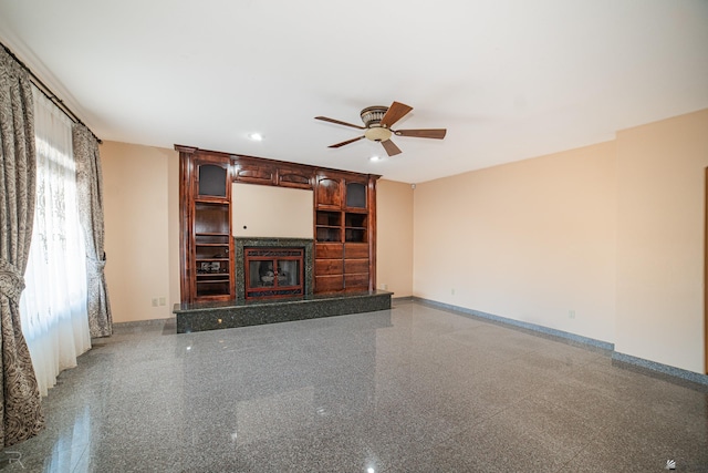 unfurnished living room with baseboards, a ceiling fan, a glass covered fireplace, and recessed lighting