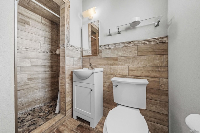 2621 S Walnut Ave, Yuma, AZ 85364 - bathroom with vanity, a tile shower, tile walls, and a wainscoted wall