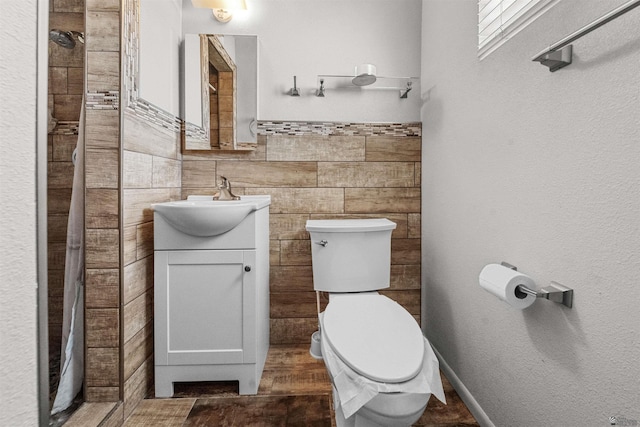 2621 S Walnut Ave, Yuma, AZ 85364 - bathroom featuring vanity, a tile shower, tile walls, a wainscoted wall, and wood finished floors