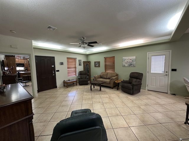 14411 E 50th Dr, Yuma, AZ 85367 - living area with light tile patterned flooring, ceiling fan, a textured ceiling, and a raised ceiling