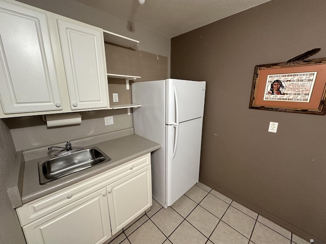 14411 E 50th Dr, Yuma, AZ 85367 - kitchen with open shelves, white cabinets, freestanding refrigerator, light tile patterned floors, and light countertops