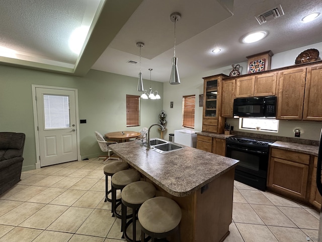 14411 E 50th Dr, Yuma, AZ 85367 - kitchen featuring black appliances, dark countertops, light tile patterned floors, a breakfast bar area, and a textured ceiling