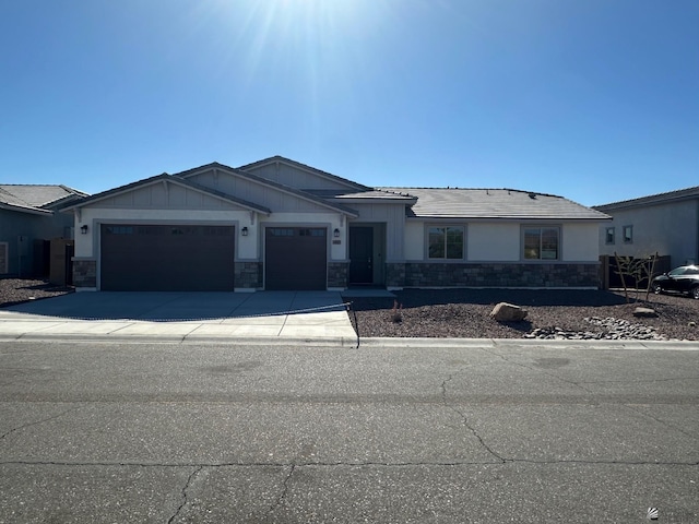 14691 E 42nd St, Yuma, AZ 85367 - view of front of property featuring an attached garage, stone siding, concrete driveway, and board and batten siding