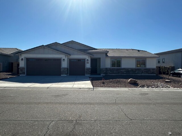 14691 E 42nd St, Yuma, AZ 85367 - view of front of property featuring an attached garage, stone siding, concrete driveway, and board and batten siding