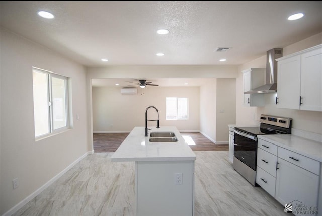 350 S Monte Vis, Yuma, AZ 85364 - kitchen with wall chimney range hood, electric range, a sink, a kitchen island with sink, and visible vents