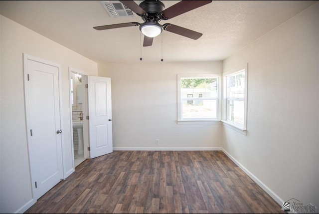 350 S Monte Vis, Yuma, AZ 85364 - unfurnished bedroom featuring baseboards, a ceiling fan, dark wood-style flooring, and visible vents