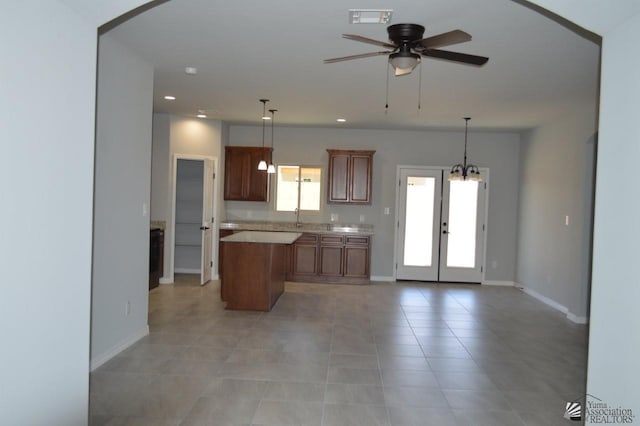 13113 E 54th St Lot 37, Yuma, AZ 85367 - kitchen with a kitchen island, light countertops, a ceiling fan, french doors, and light tile patterned floors