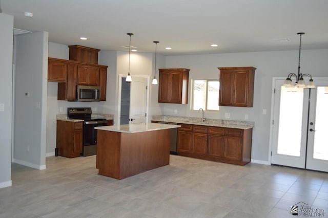 13113 E 54th St Lot 37, Yuma, AZ 85367 - kitchen featuring appliances with stainless steel finishes, a center island, french doors, a chandelier, and decorative light fixtures