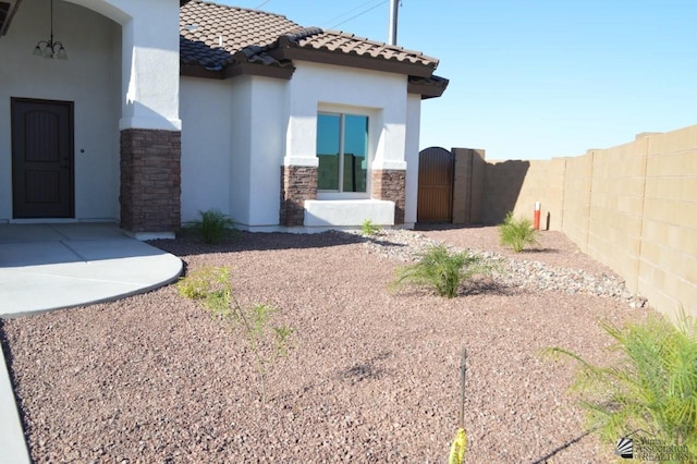 13113 E 54th St Lot 37, Yuma, AZ 85367 - exterior space with stucco siding, stone siding, a tile roof, and a gate