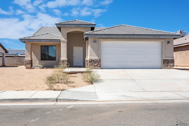 3830 E Jett St, San Luis, AZ 85336 - view of front of house with stone siding, concrete driveway, a tile roof, and stucco siding
